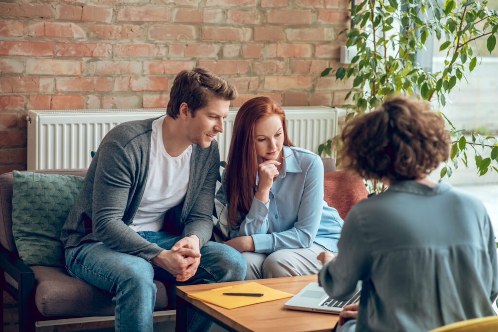 Young couple in office communicating with broker